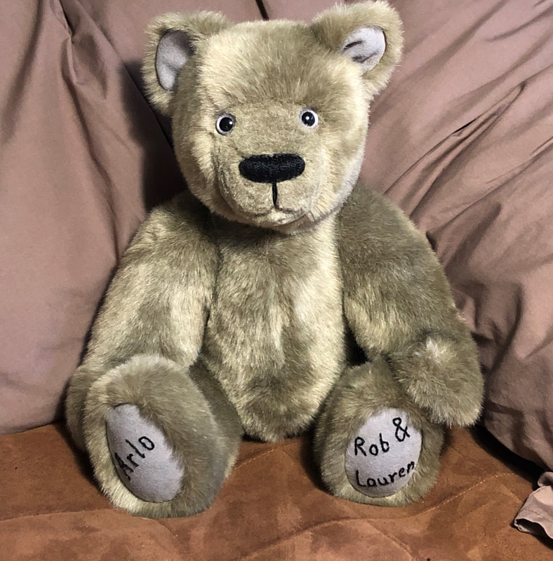 Silver grey plush bear with 'Arlo' embroidered on one foot and 'Rob & Lauren' on the other